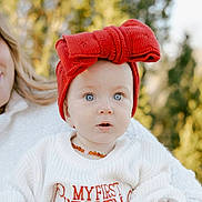 Alexis joined the competition — help win amazing prizes! baby, child, red_bow, headband, sweater, my_first_christmas, holiday, portrait, outdoor, nature, blue_eyes, knitwear, cute, infant, person, face, smile, winter_clothing, necklace, family