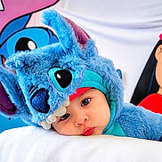 Kai joined the competition — help win amazing prizes! baby, child, costume, blue, plush, face, portrait, cute, expression, headwear, soft, resting, indoor, colorful, character, disney, stitch, clothing, person, closeup