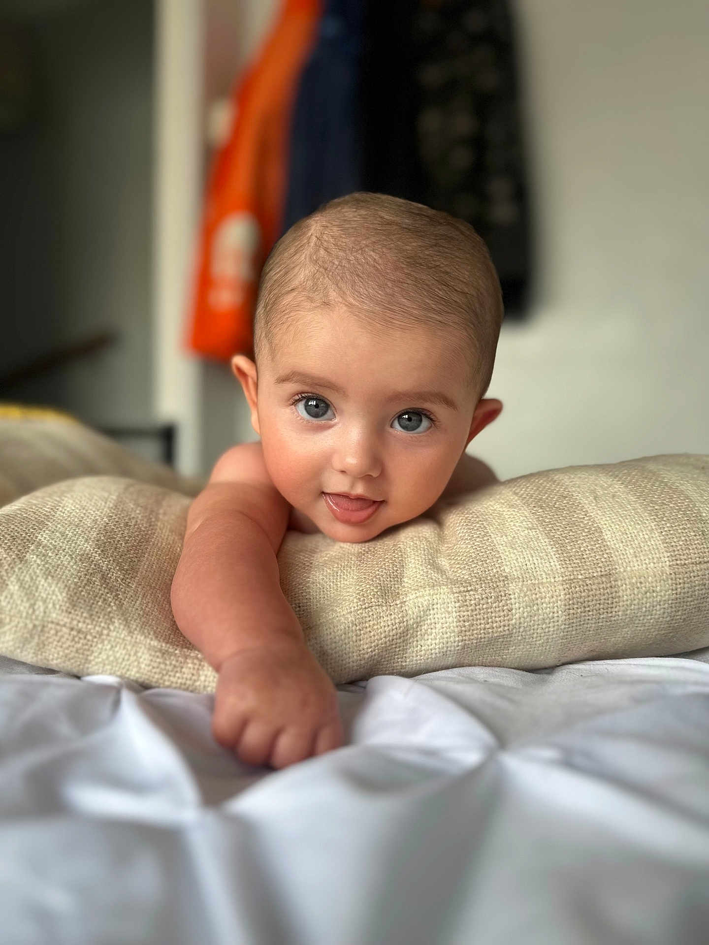 Meliha is registered to the contest to win money with this photo: baby, infant, face, blue_eyes, smiling, arm, hand, pillow, bed, blanket, skin, head, cute, expression, indoors, person, portrait, young_child, comfort, focus