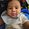 Bryson is registered to the contest to win money with this photo: baby, child, face, tongue, bib, clothing, smile, person, indoor, cute, infant, portrait, young, happy, skin, head, eyes, playful, fabric, blanket