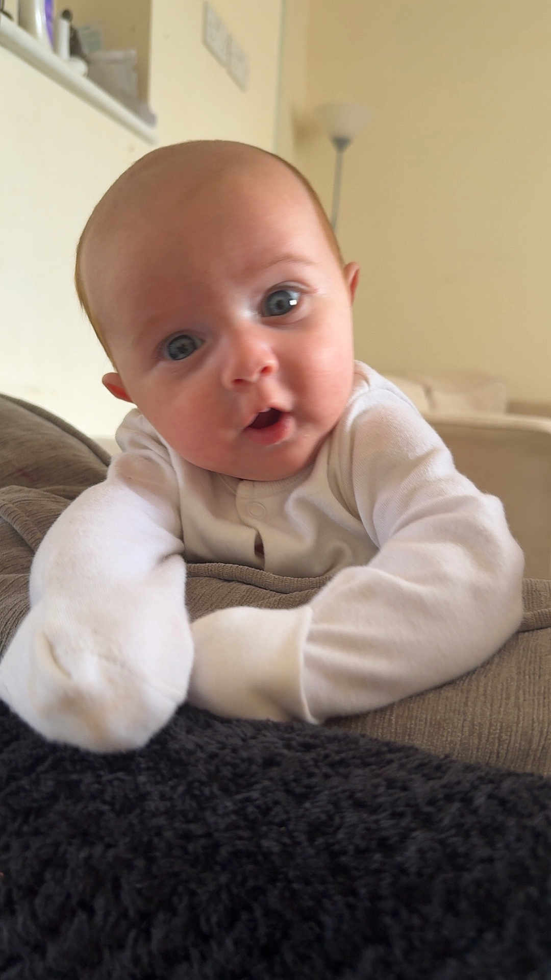 Elliot joined the competition — help win amazing prizes! baby, infant, face, eyes, white_clothing, pajamas, indoor, couch, blanket, curious, expression, skin, head, arm, soft_lighting, home, person, portrait, young_child, cozy