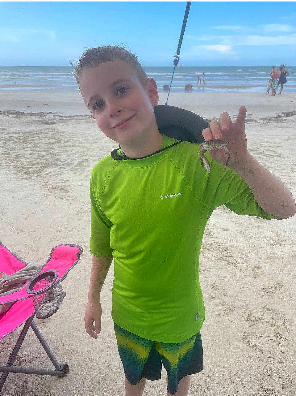 Logan joined the competition — help win amazing prizes! child, boy, beach, sand, ocean, sea, smile, green_shirt, hat, crab, chair, folding_chair, shorts, vacation, summer, shore, water, person, smiling, sunny