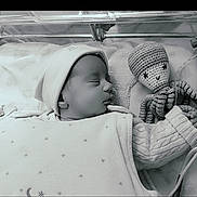 Fatma participe au concours pour gagner de l'argent avec cette photo : baby, sleeping, hat, knitted_toy, octopus, blanket, cozy, infant, crib, peaceful, monochrome, soft_light, cute, child, portrait, resting, clothing, hand, toy, closeup