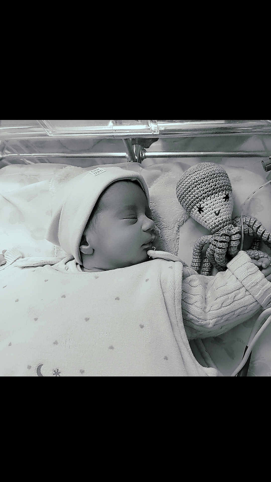 Fatma participe au concours pour gagner de l'argent avec cette photo : baby, sleeping, hat, knitted_toy, octopus, blanket, cozy, infant, crib, peaceful, monochrome, soft_light, cute, child, portrait, resting, clothing, hand, toy, closeup