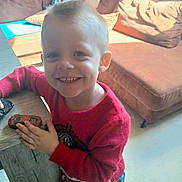 Noah participe au concours pour gagner de l'argent avec cette photo : boy, casual, child, couch, cozy, cute, daylight, furniture, happy, home, indoor, living_room, person, playing, portrait, red_sweater, short_hair, smiling, toy_car, wooden_table