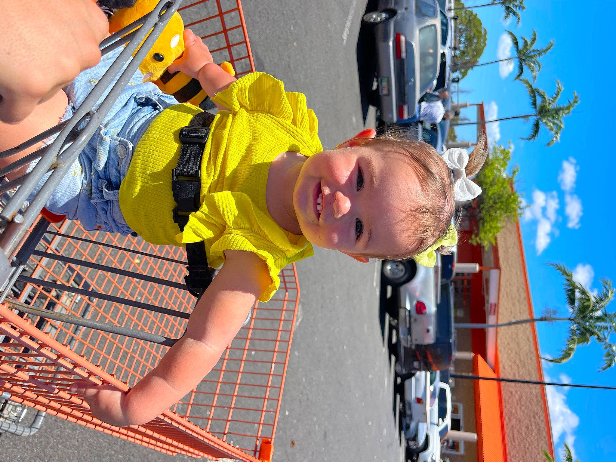 Arabella is registered to the contest to win money with this photo: automotive_exterior, car, child, fun, leisure, motor_vehicle, person, personal_protective_equipment, play, recreation, shorts, sky, smile, sunglasses, t_shirt, tire, toddler, vehicle, vehicle_door, wheel