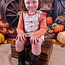 autumn, background, boots, child, curly_hair, decorations, fall_decor, festive, happy, harvest, indoor, orange_shirt, portrait, pose, pumpkins, rustic, seasonal, smile, vest, wooden_chest