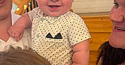 Sterlin is registered to the contest to win money with this photo: baby, child, smile, polka_dot, shirt, indoor, staircase, wood, railing, lights, family, adult, holding, happy, portrait, face, skin, people, candid, toddler
