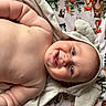 baby, smiling, towel, hood, ears, blanket, animal_pattern, cute, chubby, teeth, infant, lying_down, skin, blue_eyes, happy, soft_texture, cozy, child, portrait, indoors
