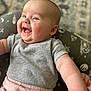baby, smiling, happy, infant, child, face, arm, clothing, gray_shirt, pink_pants, cushion, pattern, celestial, comfort, portrait, cute, skin, indoor, closeup, person