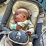 baby, infant, smile, pajamas, baby_seat, straps, face, hand, cozy, indoor, carrying_seat, comfort, pattern, star, cushion, child, happy, person, seat, soft