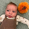 Anthony is registered to the contest to win money with this photo: baby, infant, child, portrait, lying_down, wide_eyed, smiling, open_mouth, brown_hair, overalls, onesie, clothing, plush_toy, orange_toy, blanket, polka_dots, bed, indoor, closeup, cute
