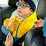 backseat, banana, beanie, boy, car_interior, casual, child, cozy, curious, eating, glasses, hand, indoor, portrait, seat, seatbelt, transportation, warm_clothes, winter_clothing, yellow_jacket