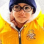 blue_jacket, casual, child, curious, expression, face, glasses, hat, headwear, jacket, knit_hat, outerwear, patch, person, portrait, space_theme, winter_clothing, yellow_jacket, young, zipper