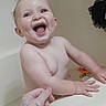 baby, bathtub, bath, child, smile, laughing, water, skin, hand, toy, bathroom, adult_hand, wet, happy, person, infant, playing, cleaning, fun, support