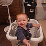 toddler, child, laundry_basket, smiling, indoor, fan, dresser, clothing, floor, household, toy, person, baby, happy, reaching, furniture, room, plastic, basket, cute