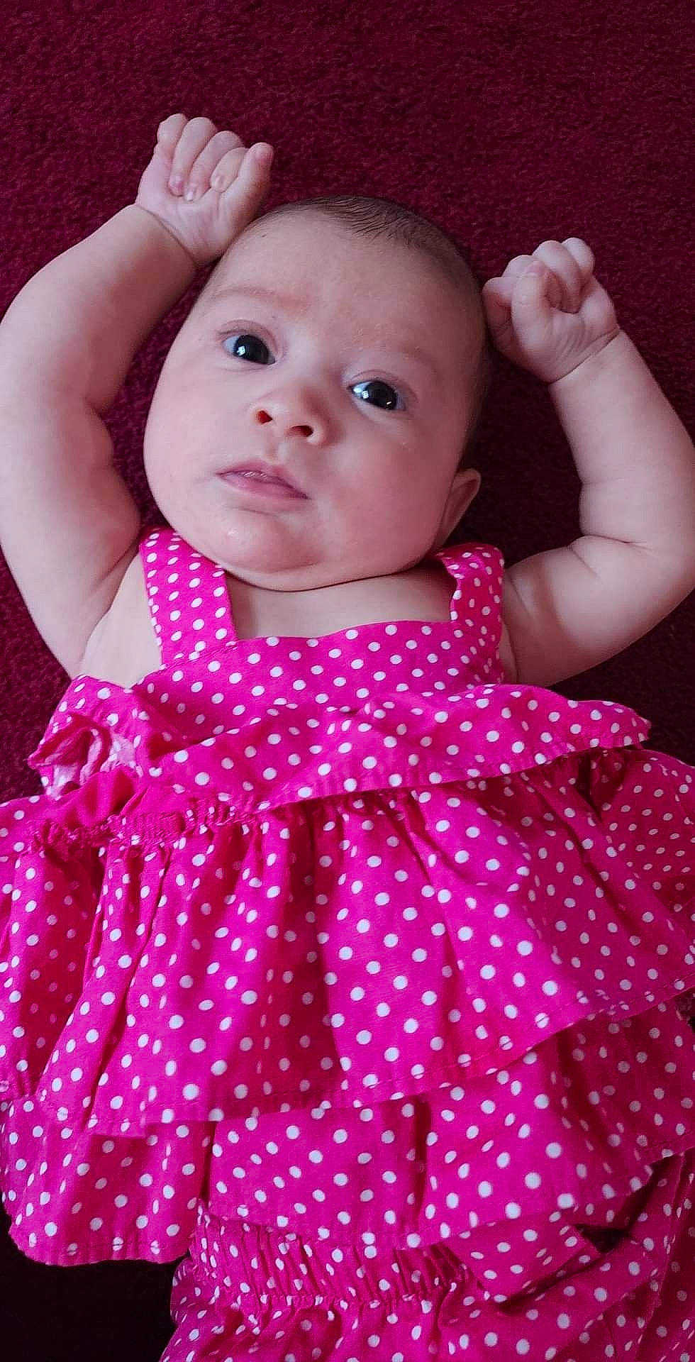 Catalina is registered to the contest to win money with this photo: arm, baby, baby_toddler_clothing, cheek, day_dress, dress, hand, lip, one_piece_garment, organ, outerwear, person, pink, product, red, skin, sleeve, standing, textile, toddler