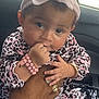 baby, infant, child, pink_bow, headband, leopard_print, bracelet, hand, rings, car_interior, window, sitting, cute, curly_hair, portrait, skin, clothing, person, baby_clothes, fingers