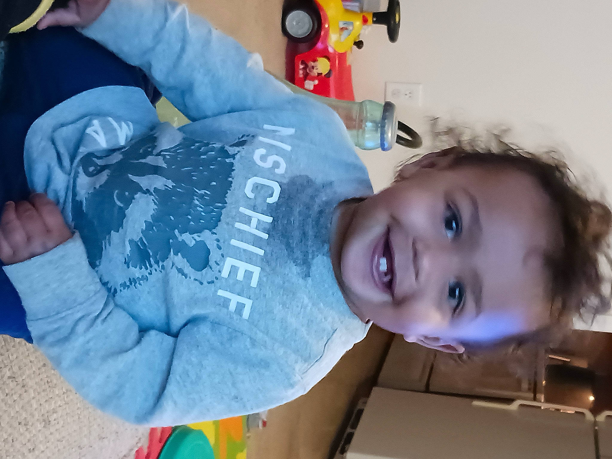 Adrian is registered to the contest to win money with this photo: baby, baby_toddler_clothing, cheek, child, clothing, electric_blue, fun, happy, hat, joy, mouth, nose, person, room, sitting, skin, sleeve, smile, t_shirt, toddler