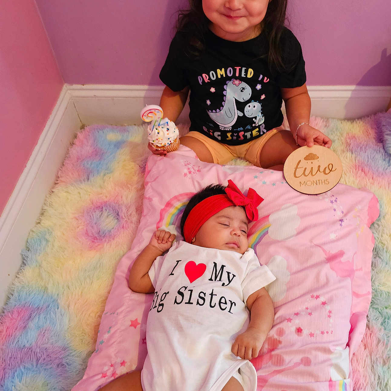 Camila joined the competition — help win amazing prizes! baby, birthday_candle, celebration, child, cupcake, cute, family, headband, indoor, lying_down, onesie, pastel_blanket, pillow, pink_wall, siblings, sitting, sleeping_baby, smiling_child, toddler, wooden_sign