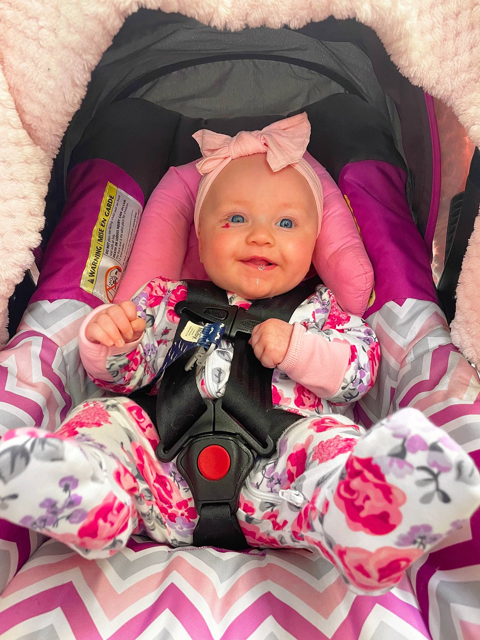 Harper is registered to the contest to win money with this photo: baby, baby_carriage, baby_toddler_clothing, cheek, comfort, eye, face, happy, head, headgear, headwear, human_body, magenta, person, pink, purple, skin, sleeve, smile, textile