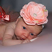 Maelys participe au concours pour gagner de l'argent avec cette photo : adorable, baby, blue_eyes, child, closeup, cute, expression, face, flower, head, headband, infant, lying_down, newborn, pink, portrait, skin, soft_lighting, toddler, young