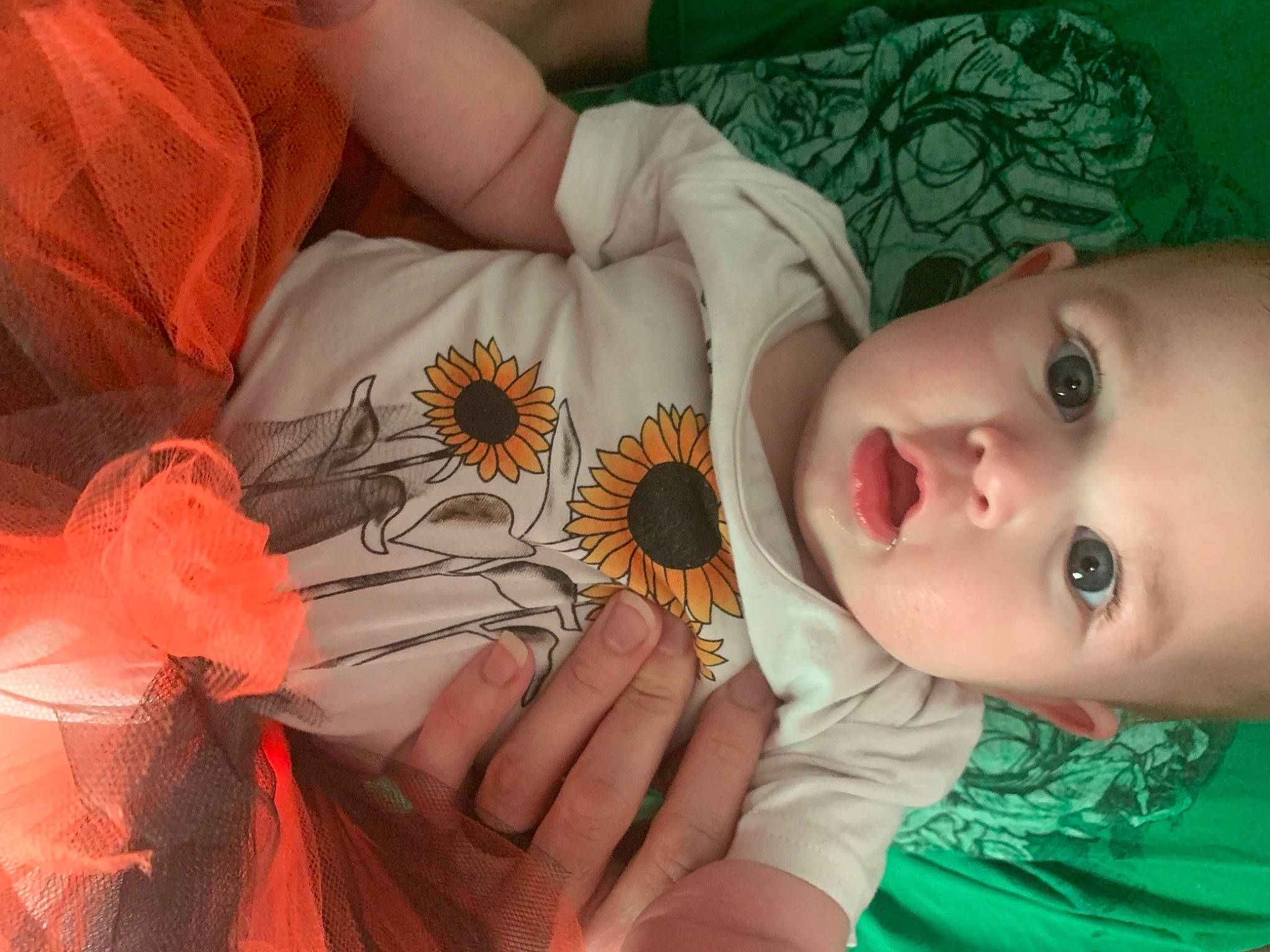 Anastasia is registered to the contest to win money with this photo: baby, baby_toddler_clothing, eye, eyelash, finger, flower, green, hand, happy, iris, leaf, lip, mouth, nail, orange, person, petal, plant, skin, textile