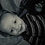 Jovanni is registered to the contest to win money with this photo: baby, child, smiling, striped_shirt, blanket, portrait, face, infant, cute, lying_down, happy, person, black_and_white, closeup, young_child, indoors, head, hand, eyes, clothing