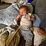 William joined the competition — help win amazing prizes! baby, infant, child, portrait, sitting, couch, blanket, star_pattern, clothing, onesie, pants, sock, face, hands, indoor, home, furniture, cushion, relaxed, awake