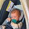 baby, infant, car_seat, pacifier, harness, vehicle, sitting, portrait, face, eyes, hair, clothing, blanket, sleeper, newborn, indoor,  안전, cozy, child, photography