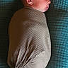 baby, sleeping, swaddled, headband, bow, blanket, toes, infant, peaceful, wrapped, cute, soft, texture, portrait, newborn, resting, child, lying_down, close_up, calm