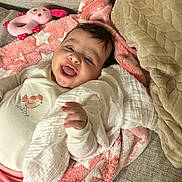 Alya a rejoint le concours — aidez-le/la à gagner de superbes lots ! baby, blanket, cheeks, couch, cozy, hand, happy, head, indoor, infant, laughing, nursery_item, onesie, pink_blanket, plush_toy, portrait, sleepwear, smile, soft_texture, tongue