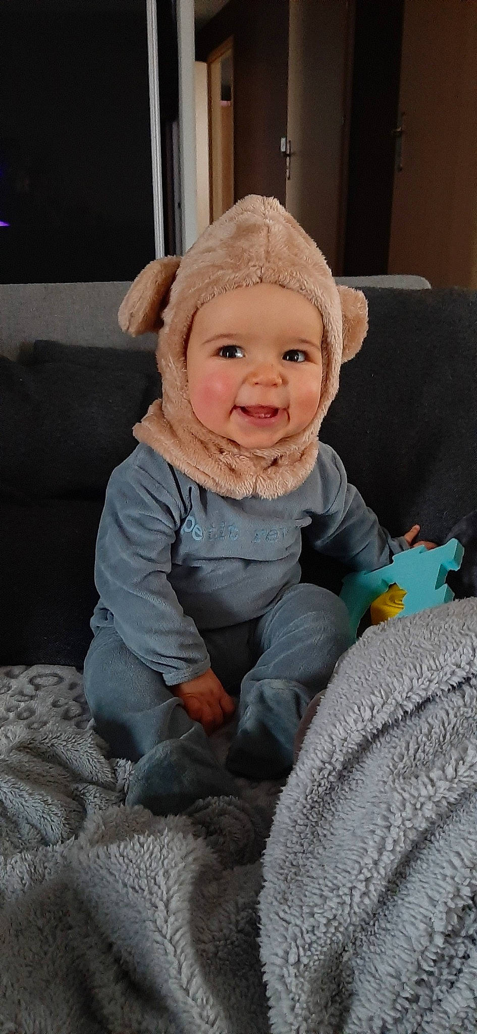 Lenny participe au concours pour gagner de l'argent avec cette photo : baby, baby_toddler_clothing, cheek, child, comfort, facial_expression, flooring, fun, happy, headwear, joy, lap, nose, outerwear, person, sitting, skin, sleeve, smile, standing