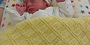 Titouan participe au concours pour gagner de l'argent avec cette photo : baby, bed, blanket, cozy, cute, hat, headwear, indoors, infant, knitted_blanket, newborn, peaceful, pillow, portrait, resting, sleeping, small_hands, soft_lighting, stars_pattern, white_clothing