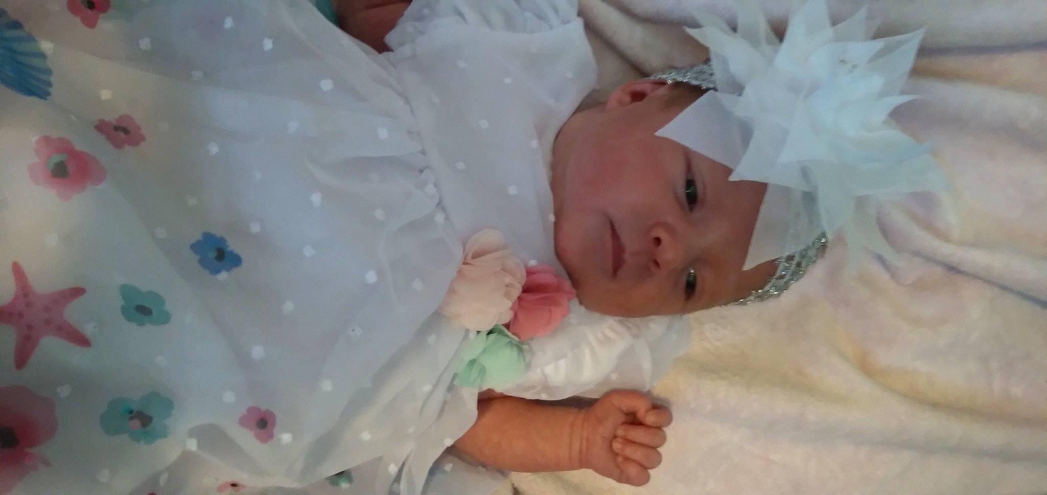 Chloe Scott is registered to the contest to win money with this photo: baby, baby_products, baby_toddler_clothing, child, comfort, embellishment, event, eyelash, hand, happy, headpiece, headwear, human_body, linens, pattern, person, pink, room, skin, sleeve