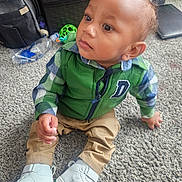 Siyawne joined the competition — help win amazing prizes! backpack, carpet, child, clothing, curious, expression, face, floor, green_vest, hand, home, indoor, person, plaid_shirt, shoe_box, shoes, sitting, toddler, toy, water_bottle