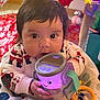 Eliana is registered to the contest to win money with this photo: baby, child, toy, glowing_toy, pajamas, holiday, christmas, decorations, indoor, seat, face, hands, closeup, cute, festive, colorful, infant, smiling, playful, warm
