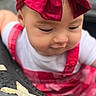 baby, child, infant, portrait, face, bow, headband, red, white, outfit, dress, suspenders, sitting, outdoor, greenery, table, food, chips, closeup, curious