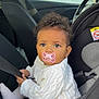 baby, car, car_interior, car_seat, child, curly_hair, cute, indoors, infant, knitwear, looking, pacifier, person, portrait, safety, seat, seatbelt, sitting, white_clothing, young_child