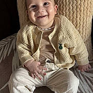 Timéo participe au concours pour gagner de l'argent avec cette photo : baby, child, smiling, knitwear, beige, cushion, pants, socks, face, happy, sitting, portrait, indoors, cozy, cute, person, apparel, texture, comfort, young