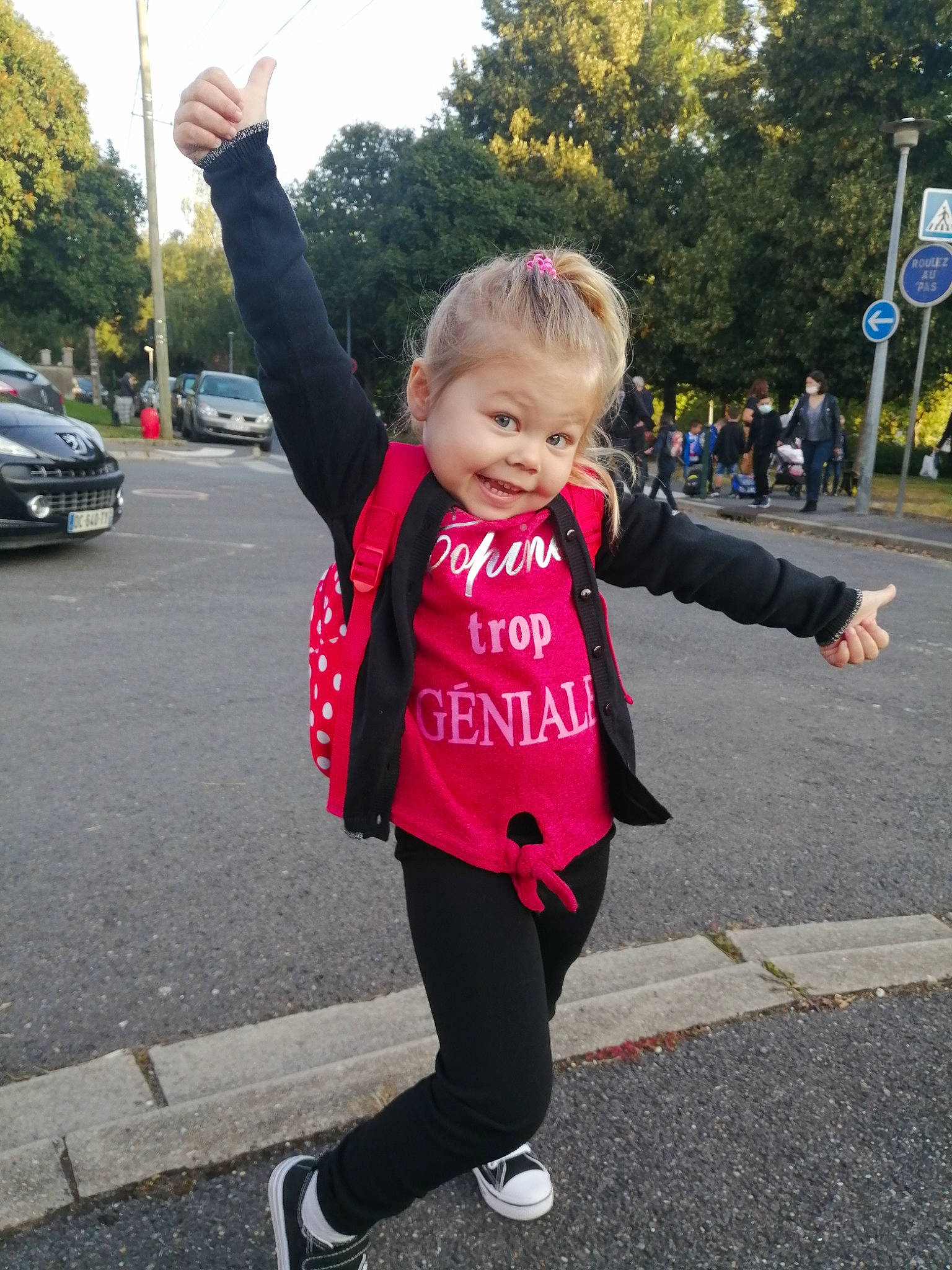 Elena participe au concours pour gagner de l'argent avec cette photo : asphalt, car, electric_blue, facial_expression, footwear, fun, gesture, happy, infrastructure, leisure, pedestrian, person, plant, recreation, road, sky, sleeve, sportswear, sweatpant, toddler