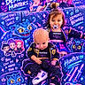 baby, toddler, children, portrait, sitting, couch, pacifier, neon, colorful, costume, fantasy, kpop, cartoon, cat, sparkles, superhero, demon_hunters, jacket, sneakers, indoor