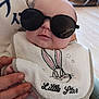 Kaaly participe au concours pour gagner de l'argent avec cette photo : baby, sunglasses, bib, bunny, little_star, hand, indoor, person, child, cute, face, clothing, accessory, portrait, infant, soft_lighting, holding, expression, closeup, adorable