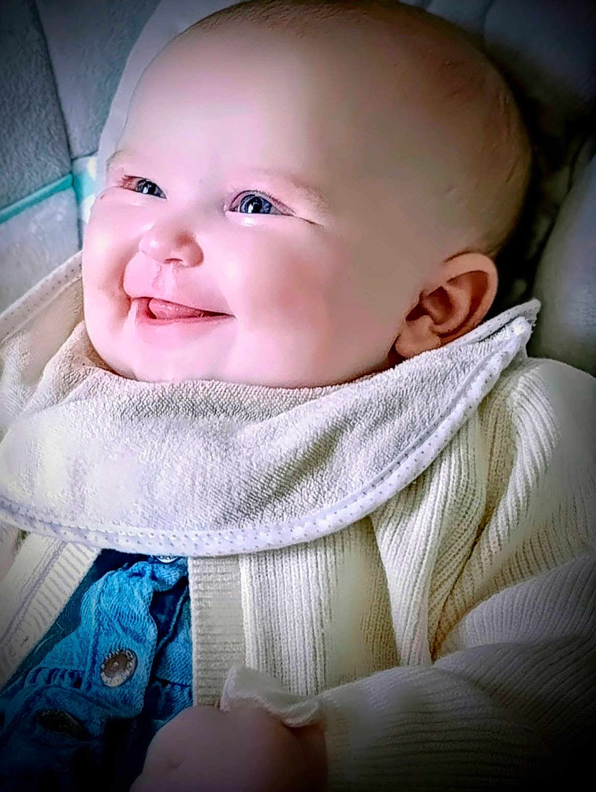 Kaaly participe au concours pour gagner de l'argent avec cette photo : baby, smile, tongue, bib, knitted_sweater, blue_clothing, cheeks, face, head, infant, cute, happy, person, portrait, closeup, child, young, cozy, warm_clothing, indoor