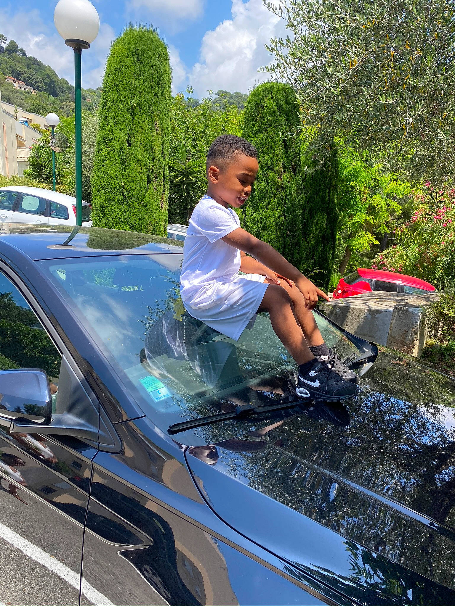 Hayckel a rejoint le concours — aidez-le/la à gagner de superbes lots ! asphalt, automotive_design, automotive_exterior, automotive_lighting, automotive_tire, automotive_wheel_system, bumper, car, cloud, hood, leisure, motor_vehicle, person, personal_luxury_car, plant, shorts, sky, tree, vehicle, vehicle_door