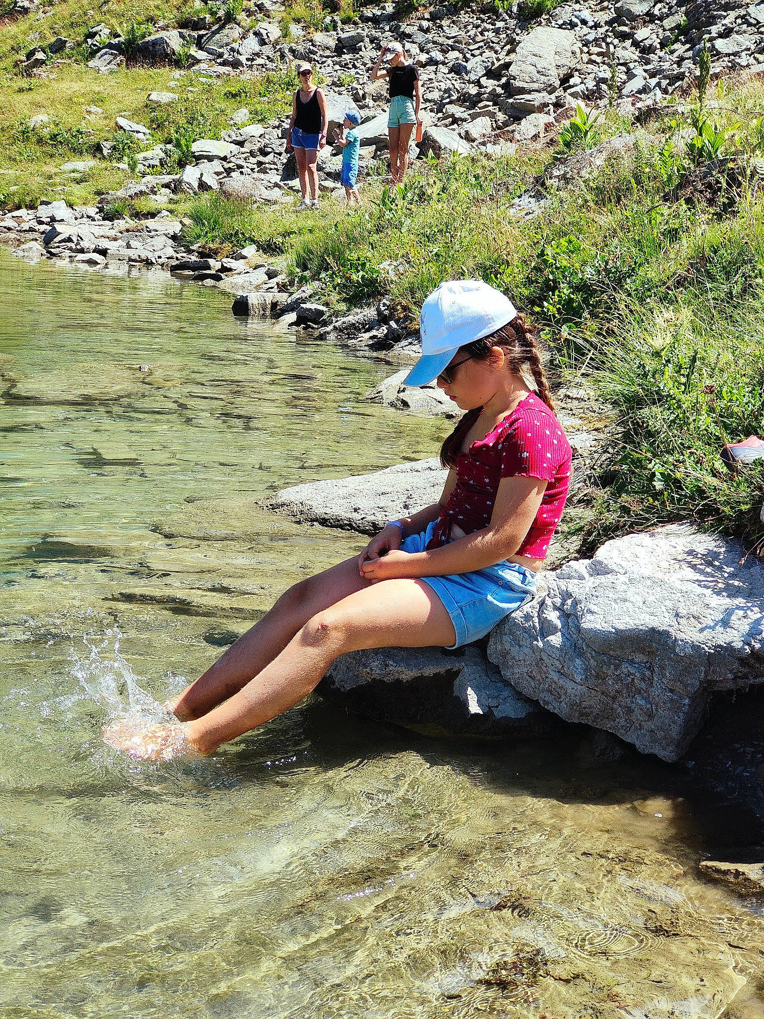 Clara a rejoint le concours — aidez-le/la à gagner de superbes lots ! adventure, baseball_cap, bedrock, cap, fluvial_landforms_of_streams, fun, geological_phenomenon, grass, hat, headwear, landscape, leisure, outdoor_recreation, people_in_nature, person, plant, recreation, rock, shorts, stream