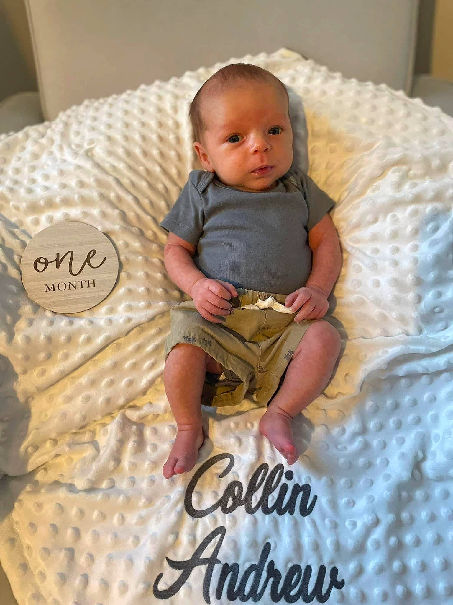 Collin is registered to the contest to win money with this photo: baby, baby_toddler_clothing, bedding, child, comfort, couch, design, font, happy, linens, pattern, person, pillow, pink, product, sitting, sleeve, t_shirt, textile, throw_pillow