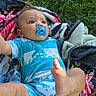 baby, pacifier, blanket, grass, outdoor, infant, blue_clothing, person, cute, lying_down, legs, arms, foot, head, face, skin, summer, playful, child, nature