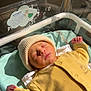Alessio a rejoint le concours — aidez-le/la à gagner de superbes lots ! newborn, baby, sleeping, hospital_bassinet, yellow_clothing, knit_hat, infant, peaceful, sunlight, indoors, blanket, resting, cute, child, portrait, soft, cozy, baby_bed, healthcare, serene