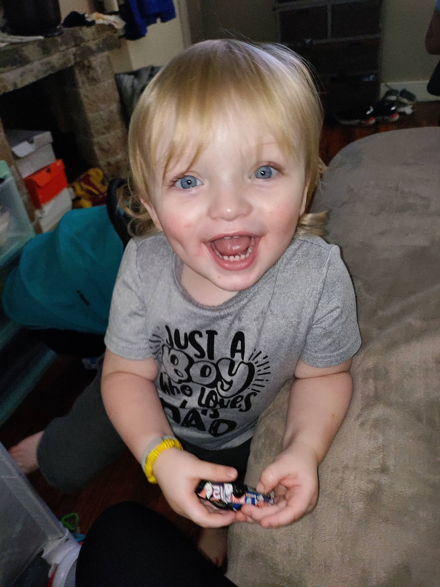 Daxtin is registered to the contest to win money with this photo: baby, baby_toddler_clothing, bangs, blond, cheek, child, flooring, fun, happy, iris, lap, person, room, sitting, skin, sleeve, smile, t_shirt, thigh, thumb